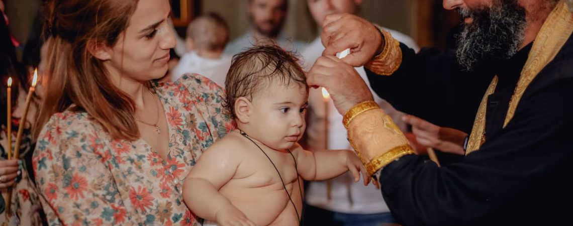 Intimate moment capturing a baby's baptism in a church with family present.